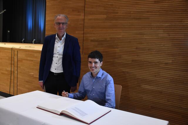 Mit Timo Benitz (sitzend) wurde im Goldenen Buch der Stadt Engen eine neue Seite aufgeschlagen. Zusammen mit Bürgermeister Johannes Moser (stehend) blätterte der hier geborene Sportler auch durch die Einträge anderer Engener Ehrengäste.