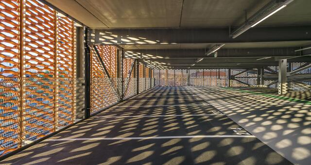 Die Fassade aus gestrecktem Aluminium im Kupferton sorgt auch für eine spannende Beleuchtung der Parkdecks. | Foto: Guido Kasper/ Büro Wuhrer