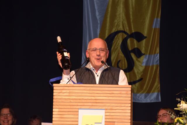 Auch der katholische Denkan, Matthias Zimmermann, brachte Geschenke, verbunden mit ideellen Gedanken mit. Darunter eine Flasche Messwein, für Moser als ehemaligem Ministrant. Früher habe man als Ministrant ja höchstens die Reste des Pfarrers abbekommen, nun gibt es für ihn eine ganze Flasche. | Foto: Anja Kurz