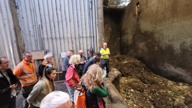 Reterra-Betriebsleiter (in Gelb) Christian Goldschmidt bei der Führung durch die Anlieferbunker für die Bioabfälle, die hier als "Rohstoff" zur Gewinnung von Biogas und damit Strom, wie für Kompost genutzt werden. | Foto: OV Grüne Singen