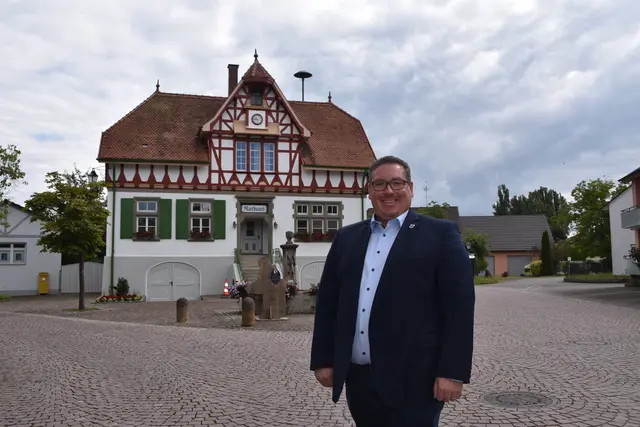 Patrick Krauss, Bürgermeister der Gemeinde Moos, vor dem Rathaus in Iznang, dessen umfangreiche Sanierungsarbeiten noch in diesem Herbst abgeschlossen werden sollen.  | Foto: Philipp Findling