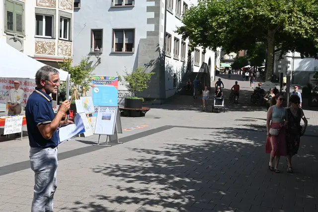 Dieter Schmalohr hält die Besucher und Passanten zu einer Mahnwache an. Er und Heinrich Schuster, der am Infostand steht, organisieren die Aktion bereits seit Jahren, um auf Kriegsopfer, Gewalt und Waffen aufmerksam zu machen. | Foto: Sebastian Ridder