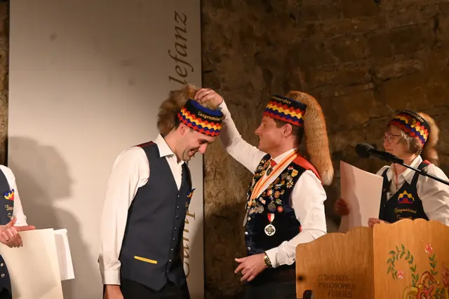 Mit der erste Akt des Abends: Rainer Hespeler (rechts) setzt Simon Götz (links) die ehrenwerte Langensteiner Narrenkappe auf. | Foto: Anja Kurz