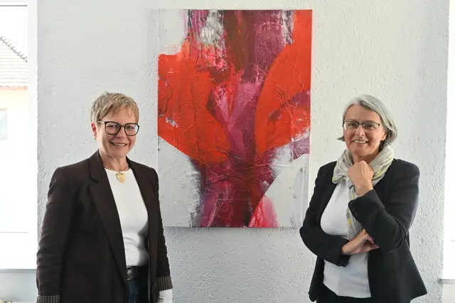 Theologin Waltraud Reichle, die die Bilder gemalt hat (rechts) und Bildungszentrumsleiterin Christine Derschka, in deren Einrichtung die Gemälde eine zeitweise Heimat gefunden haben. Die Ausstellung ist bis Ende Juni zu sehen. | Foto: Tobias Lange