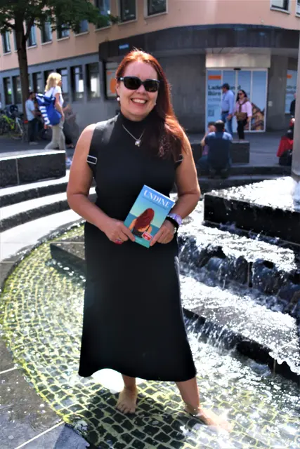 Silke U. Ferguson mit ihrem Buch "Undine", passend am kühlen Brunnen in der Singener Innenstadt.  | Foto: Philipp Findling
