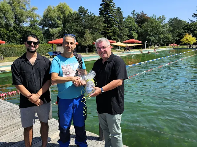 Rami Hanbaloz (Mitte) ist der 30.000ste Naturbad-Besucher, Bürgermeister Ralf Baumert und Betreiber Deniz Yilzdiz (links)überraschen ihn mit Geschenken | Foto: Sandra Bossenmaier