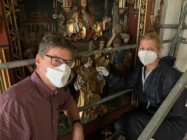 Restauratorin Melanie Bochmann (rechts) reinigt im Beisein von Pfarreiökonom Stefan Benner auf dem Baugerüst die Figur des heiligen Stephanus. | Foto: Katholische Kirchengemeinde Hegau