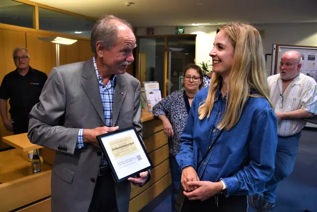 Michael Bandel überreichte der Eventmanagerin der Sparkasse Hegau-Bodensee, Johanna Rode, als Geschenk einen Notgeldgutschein aus Singen in Höhe von damals 200.000 Mark.  | Foto: Philipp Findling